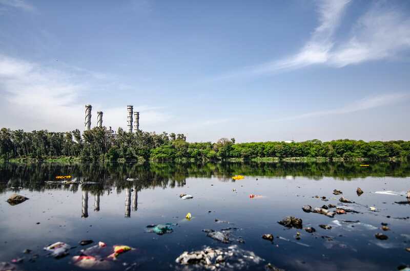 Photo d'un lac en Inde avec beaucoup de déchets au premier plan.